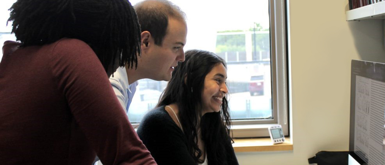 Three Cancer Biology students at a computer